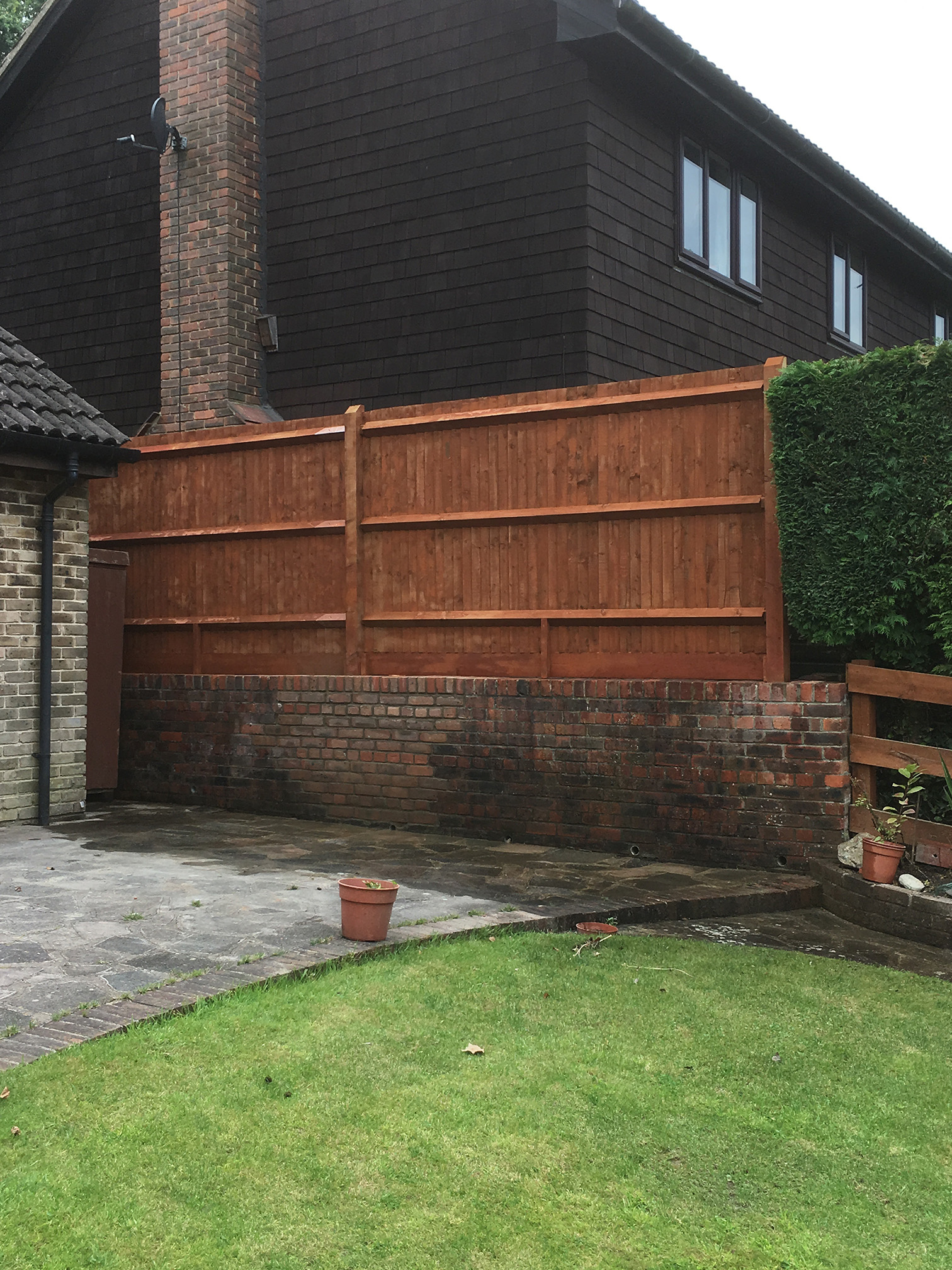 New wooden fence installed alongside repaired wall